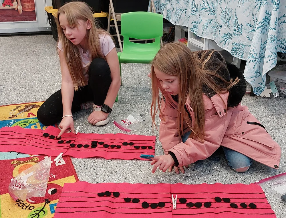 A student building a melody on the staff board