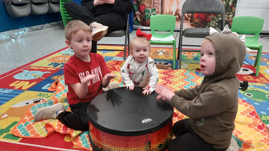 Children playing the community drum together