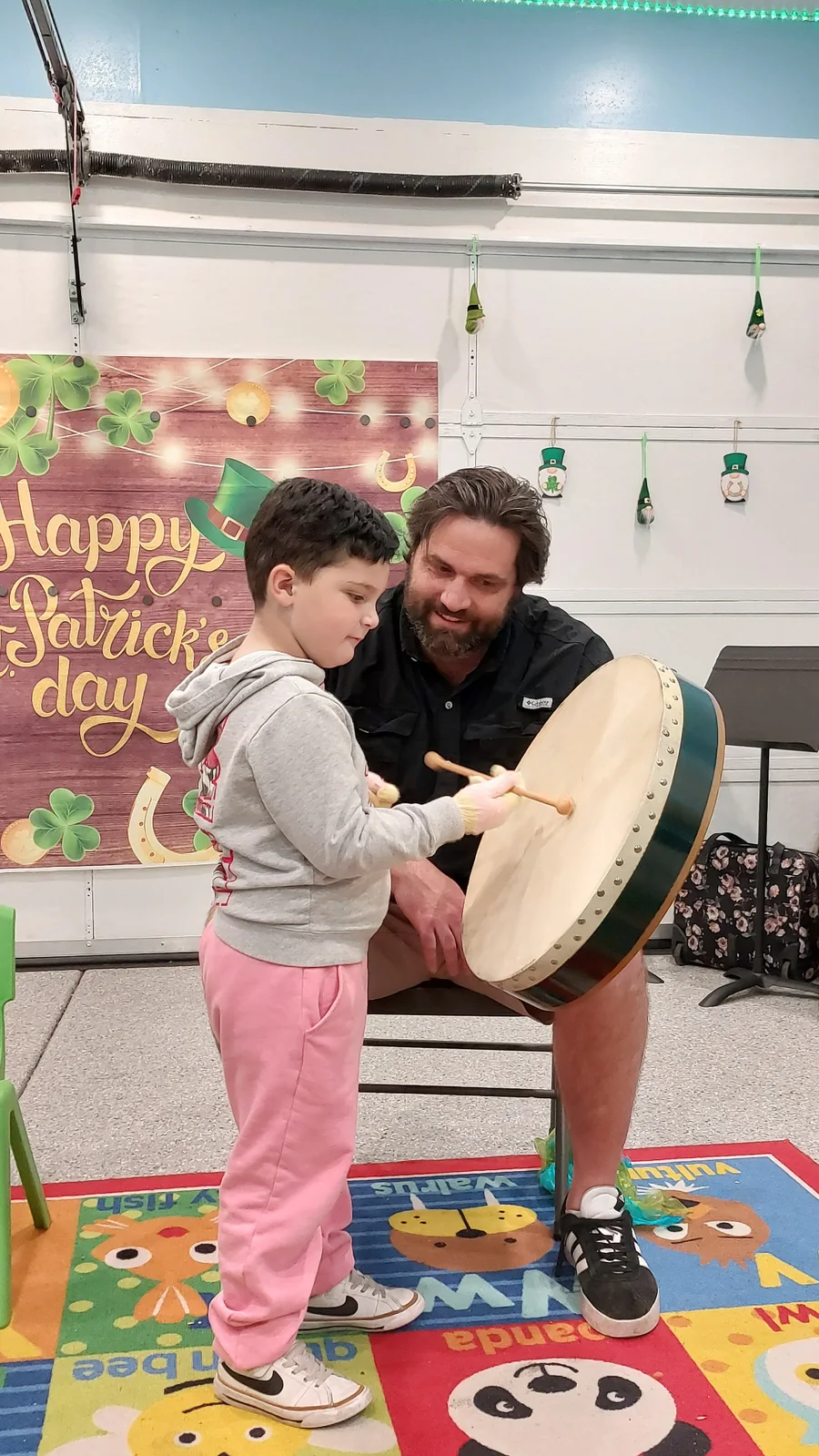 A father and son making music together on a hand drum