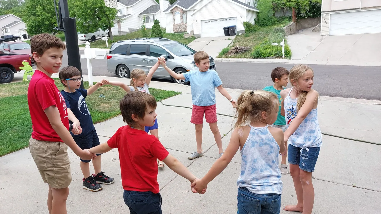 Children holding hands in a circle singing game outdoors
